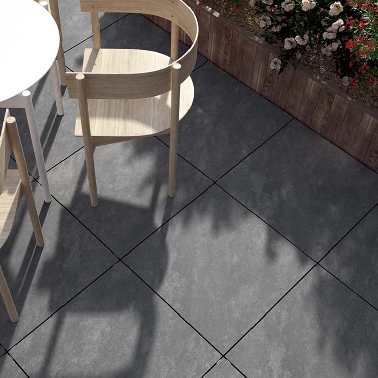 Terras van grijze terrastegels met houten stoel