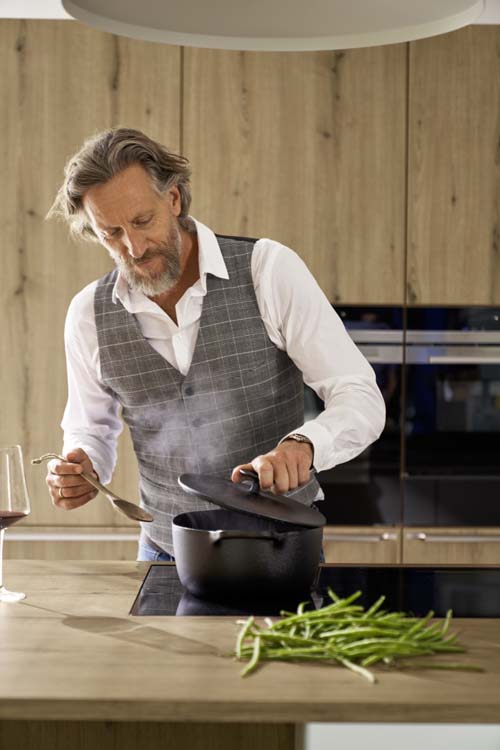 Man aan het koken in maatwerk keuken