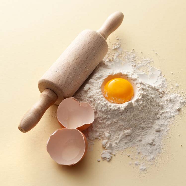 rouleau à pâtisserie avec de la farine et un œuf