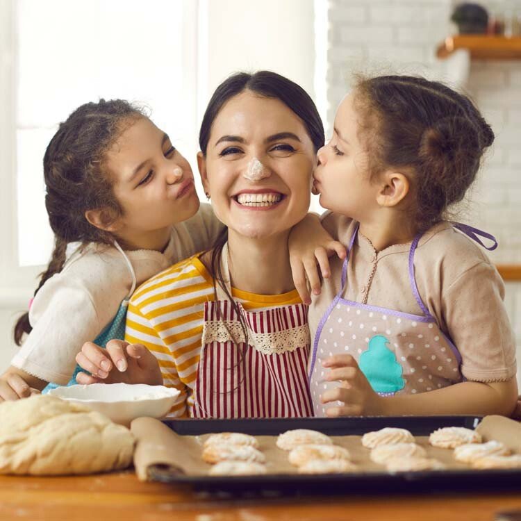 Mère et deux enfants préparant des biscuits dans la cuisine.